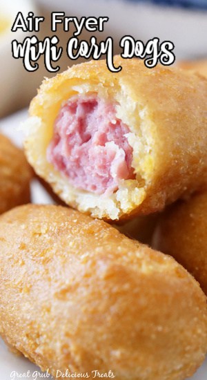 Mini Corn Dogs in Air Fryer are incredibly easy and quick to make and are a delicious crunchy snack everyone loves. A mini corn dog with a bite taken out of it.