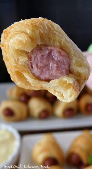 Pigs in a Blanket Air Fryer Recipe make crispy and delicious pigs in a blanket that can be cooked quickly. A bite taken out of a pig in a blanket, showing the little smokie inside.