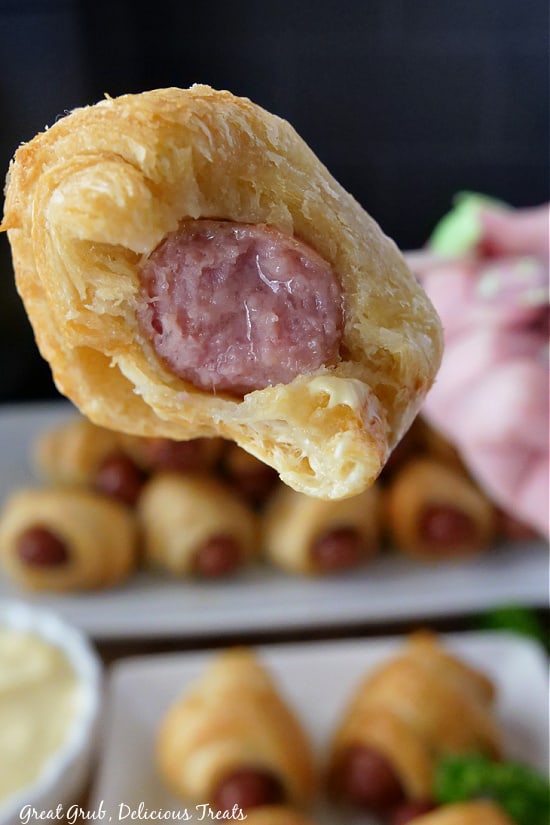 Pigs in a Blanket Air Fryer Recipe are delicious, crispy, and cooked quickly, giving you the perfect appetizer or snack for any occasion. A bite taken out of a pig in a blanket showing the little smokie center.