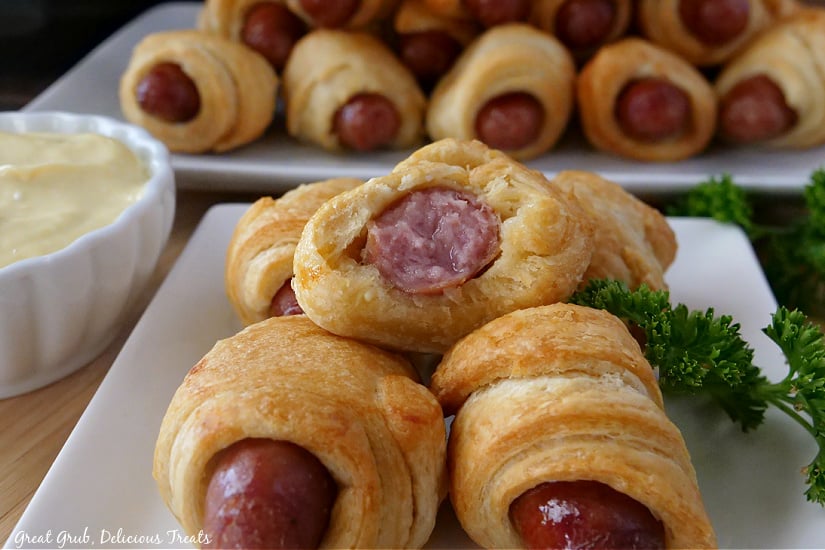 Pigs in a Blanket Air Fryer Recipe are super easy to make and are the perfect appetizer for all occasions. A white plate with crescent roll little smokies and a small white bowl filled with dipping sauce.