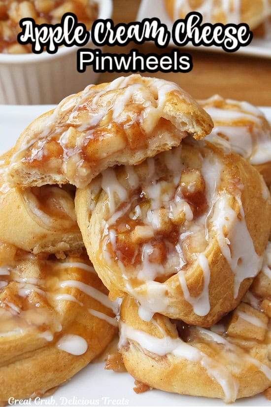A white plate with a stack of apple cream cheese pinwheels, with one of them having a few bites taken out of it.