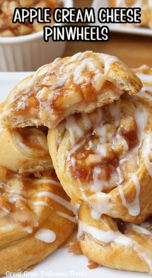 A small stack of apple pinwheels with a bite taken out of the pinwheel on top.