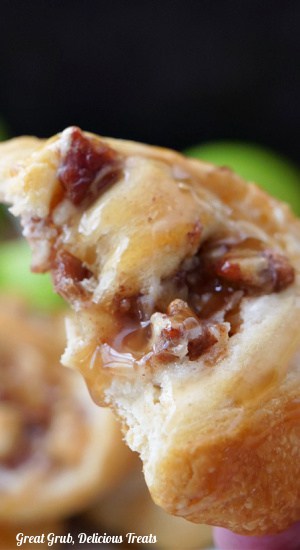 A crescent roll with a bite taken out of it held up to the camera lens for a close up view.