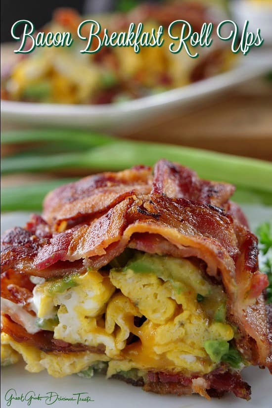 A slice of bacon breakfast roll up placed on a white plate.