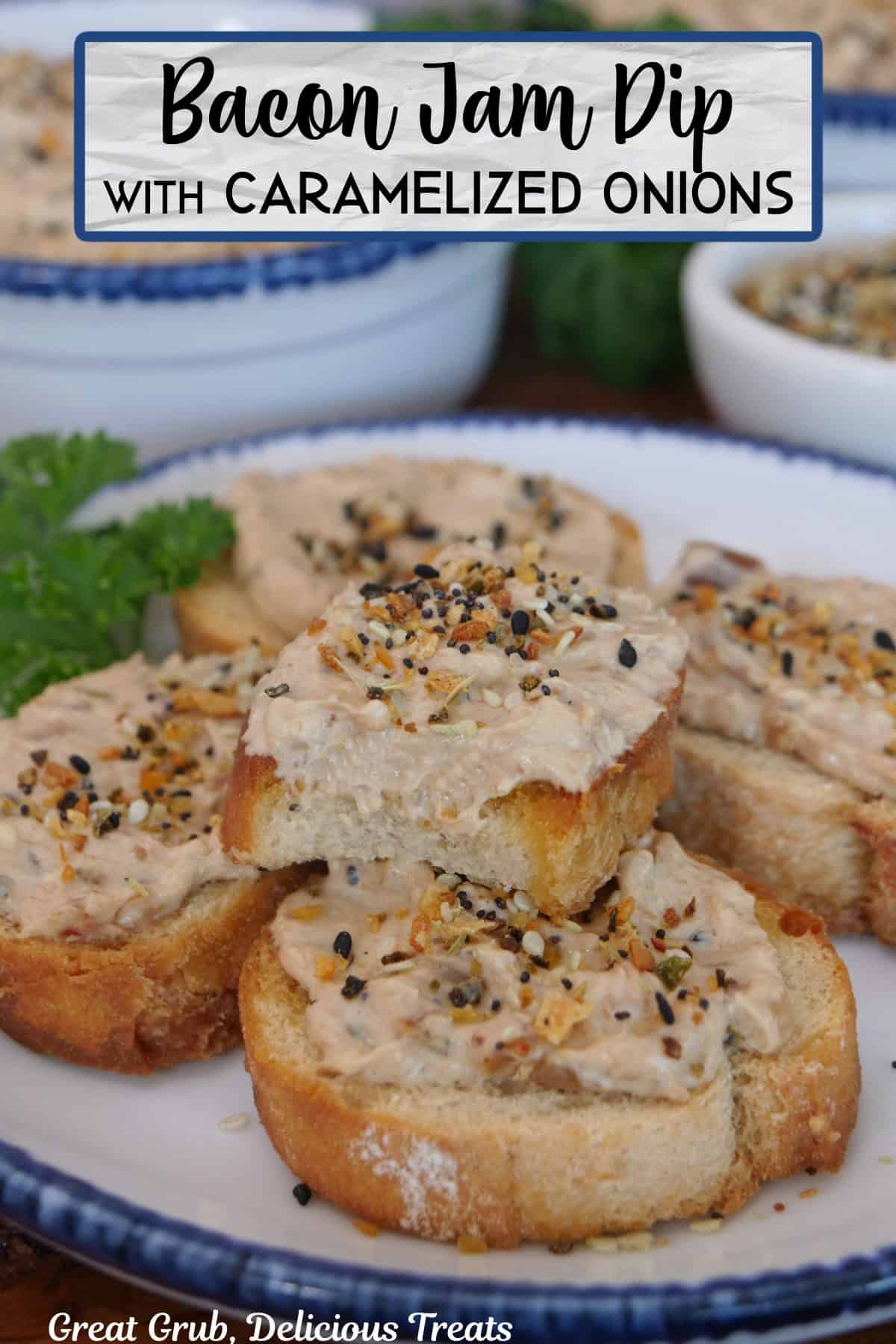 A white round plate with blue trim with slices of baguettes on it with bacon jam dip spread over them.