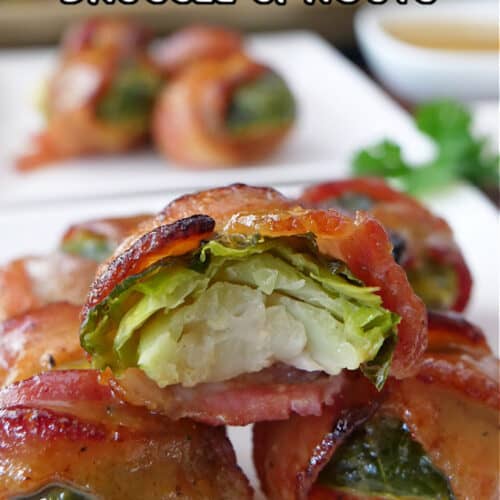 White plates with bite-size bacon wrapped brussel sprouts on them.