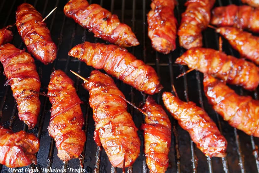 The smoker grill grates with smoked chicken strips that are wrapped in bacon.