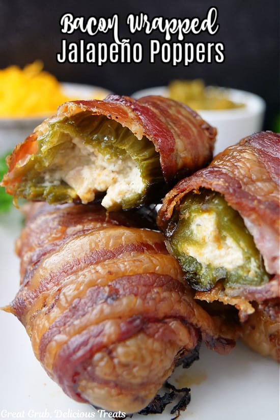 A couple bacon wrapped jalapeno poppers on a white plate.