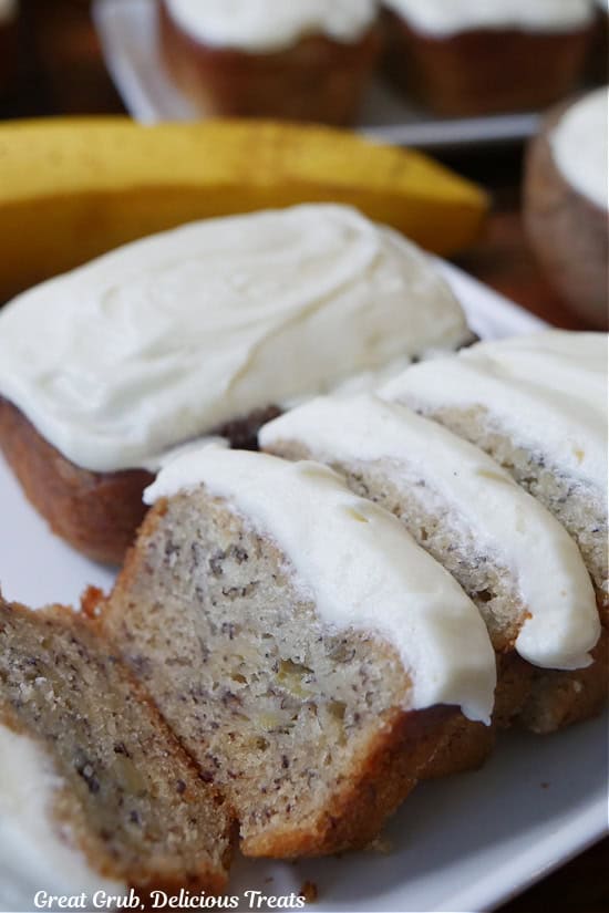 Two mini loaves of banana nut bread with one of the loaves that is sliced.