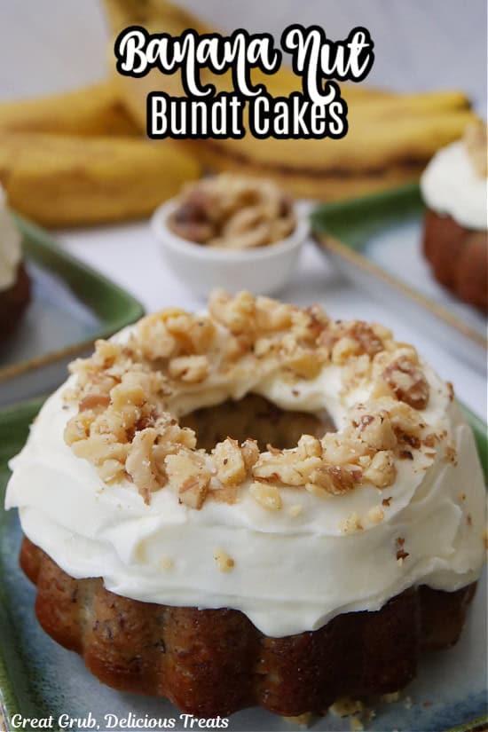 A individual banana nut bundt cake on a green and white plate topped with cream cheese frosting and chopped walnuts.