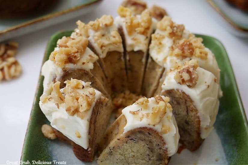 An individual frosted banana bundt cake that is sliced into bite-size pieces.