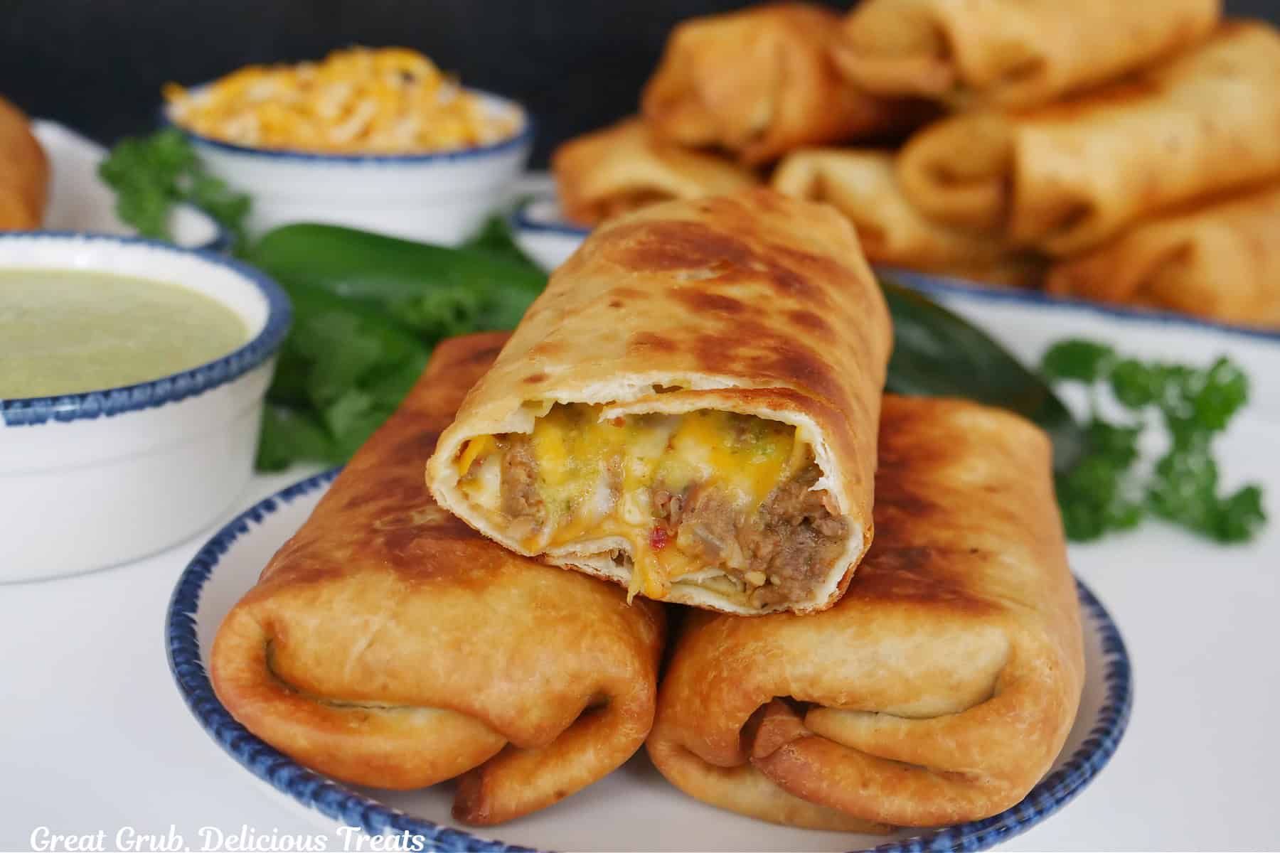 A white surface with three fried burritos on a white plate with blue trim, and the title overlay at the top.