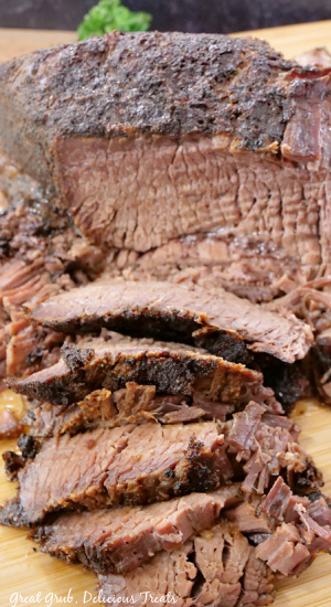A few slices of brisket on a wood cutting board.
