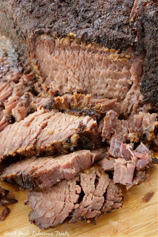 A close up of slices of brisket on a wood cutting board.