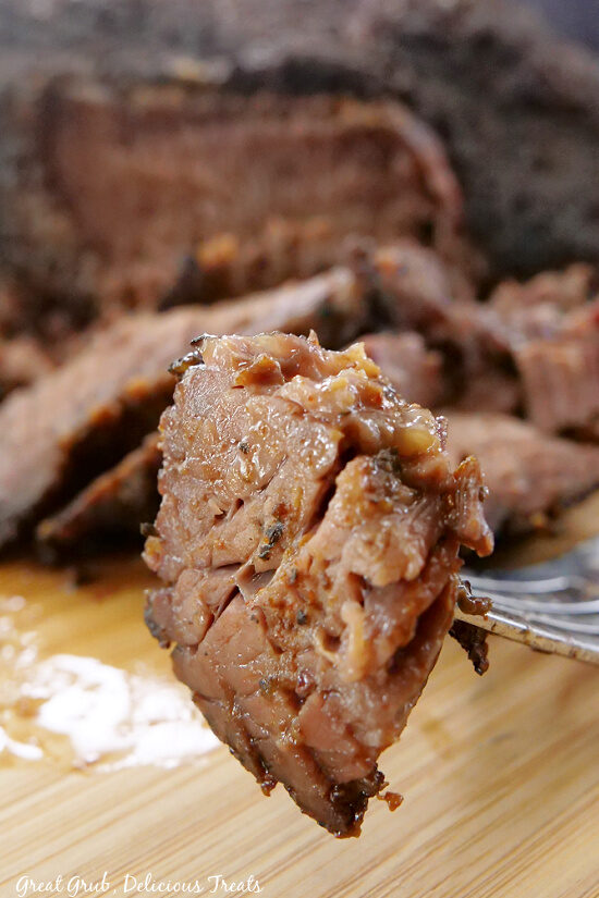 A close up bite of a piece of brisket on a fork.