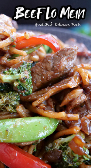 Beef Lo Mein is a filling and delicious lo mein recipe that is loaded with tender beef and fresh vegetables. A close up photo of lo mein noodles with tender beef, and sliced veggies.