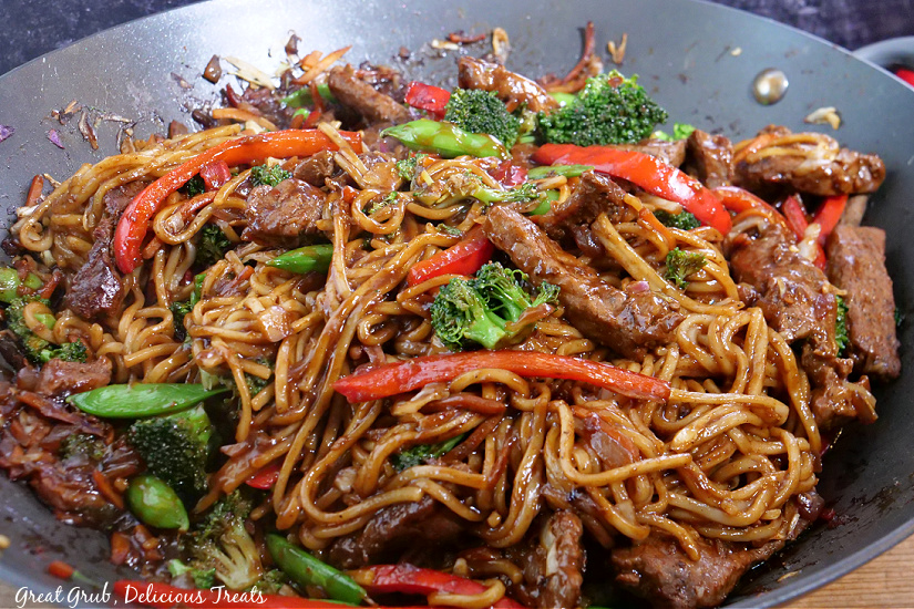 Beef Lo Mein is a homemade lo mein recipe that is made with a delicious sauce, fresh vegetables, and tender and perfectly seasoned beef. A large wok with lo mein noodles, veggies, and beef.