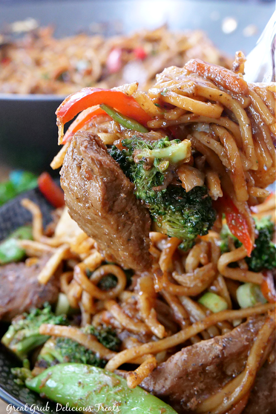Beef Lo Mein is the perfect homemade Chinese dish that you can make right at home. A big bite of beef lo mein on a fork.