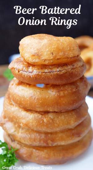 A stack of onion rings on a white plate with the title of the recipe at the top of the photo.