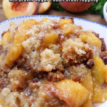 A white bowl with blue trim filled with a serving of peach cobbler.