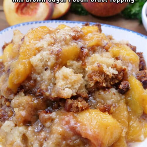 A white bowl with blue trim filled with a serving of peach cobbler.