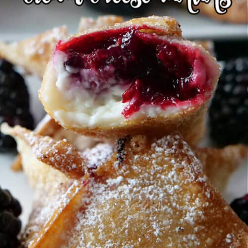 A close up picture of a wonton with a bite taken out of it, showing the fruit filling and the cream cheese.