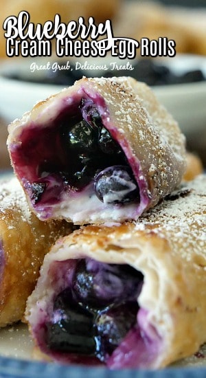 Blueberry Cream Cheese Egg Rolls are a delicious and easy dessert recipe filled with a cream cheese mixture and a fresh blueberry filling. A close up of a few egg rolls on a plate with bites taken out of them showing the inside ingredients.