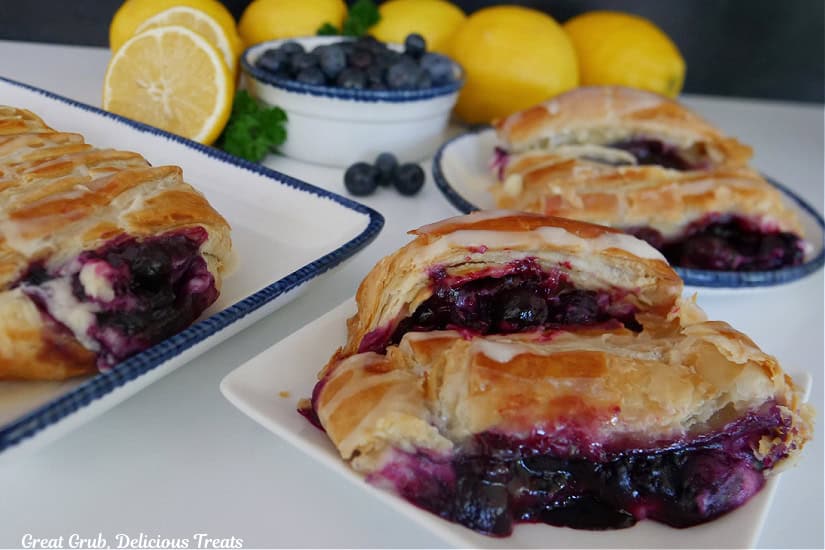 Slices of blueberry pastry braids on white plate with blue trim.