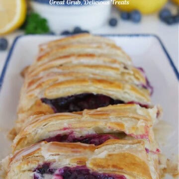 A pastry braid on a white plate with blue trim.