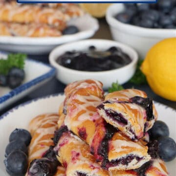A round white plate with blue trim with blueberry pastry twists on it with more in the background, and a title overlay at the top.