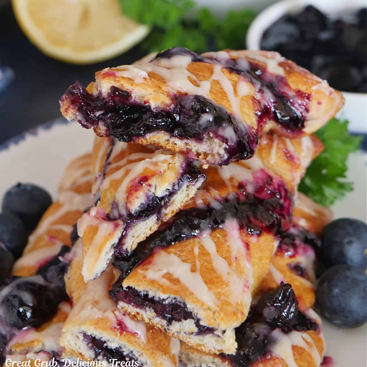 A small stack of blueberry twists on a white plate with blue trim.