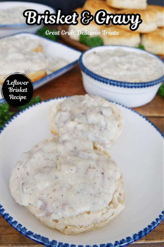 A white plate with blue trim with two biscuits on it that are topped with homemade brisket gravy.