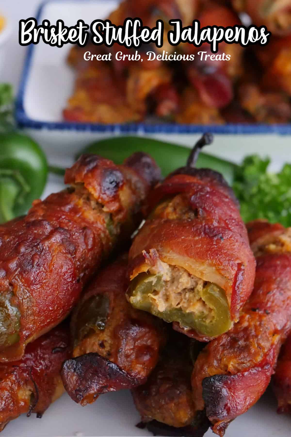 A white plate with blue trim with bacon wrapped jalapeno stuffed with brisket and a cheesy mixture.