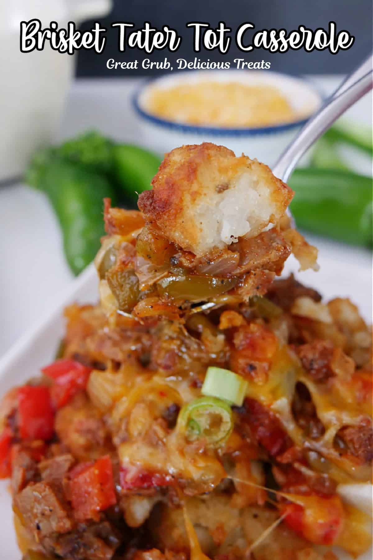 A white plate with a serving of brisket tater tot casserole on it with a bite on a fork.