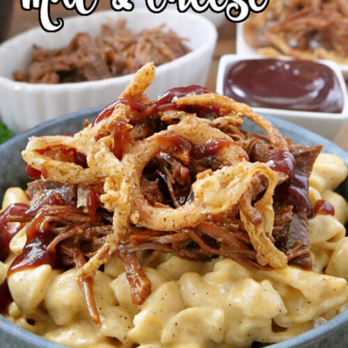 A gray bowl filled with mac and cheese, a small white bowl in the background filled with shredded brisket, and another bowl filled with BBQ sauce.