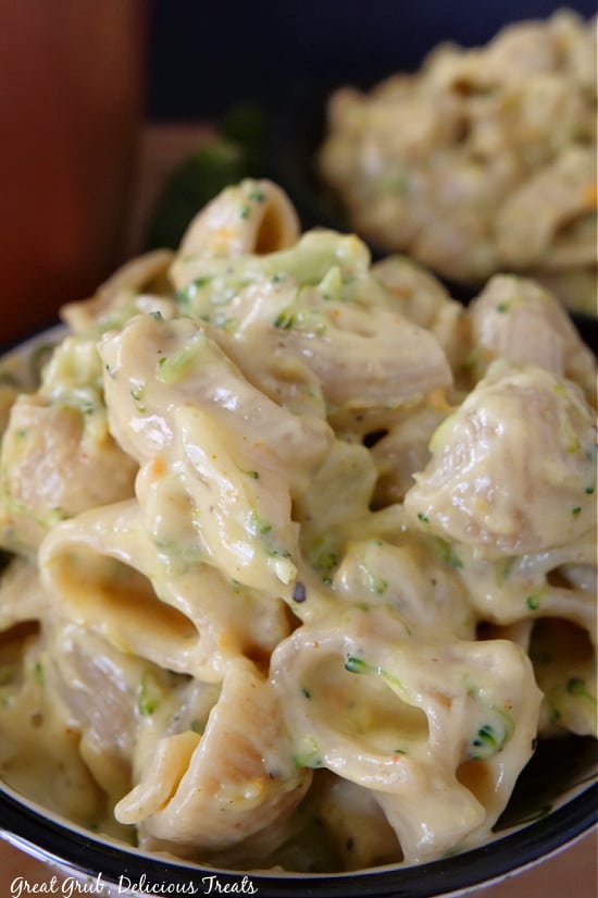 Broccoli Cheddar Mac and Cheese is a delicious and creamy mac and cheese recipe that is loaded with cooked broccoli and shredded carrots that the whole family will enjoy. A close up photo of broccoli mac and cheese in a black bowl.