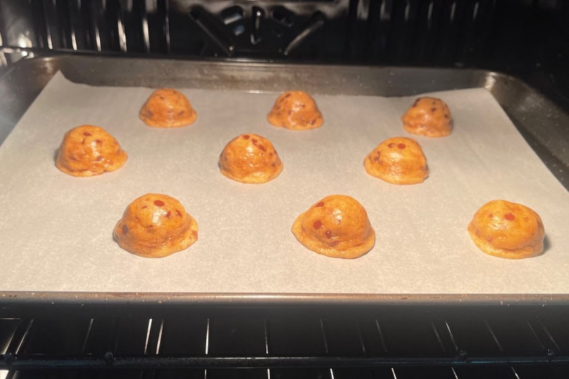 A baking sheet in the oven with the cookies starting to melt and bake.