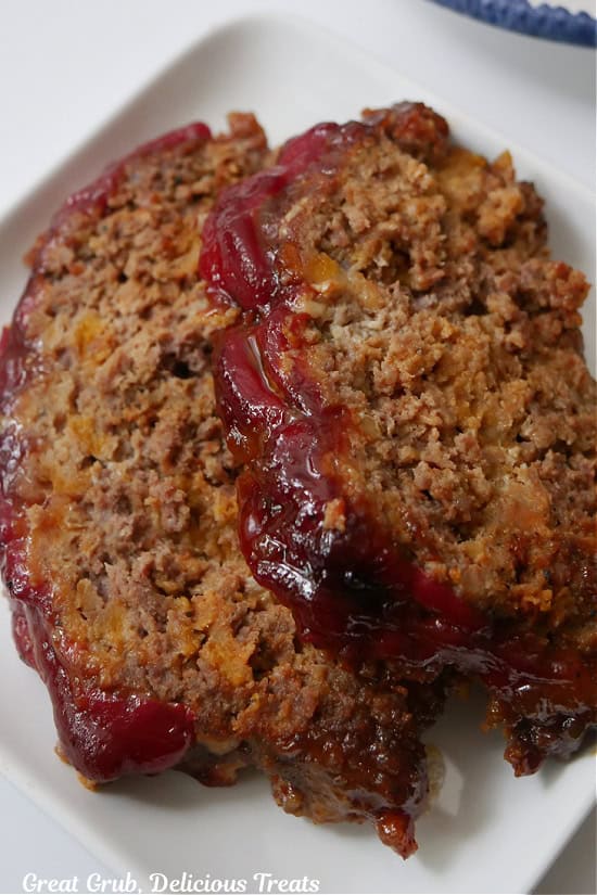 Two slices of brown sugar meatloaf on a white plate.
