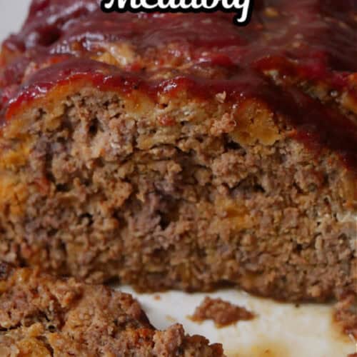 A white plate with meatloaf on it with a few slices removed.