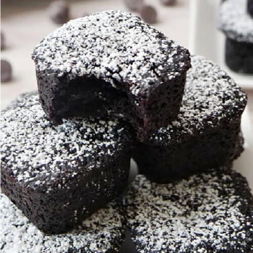 Mini brownie bites with powdered sugar on top of each one.