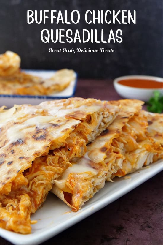 A white oblong plate with  wedges of buffalo chicken quesadillas on it.