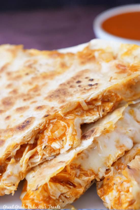 A close up photo of three pieces of buffalo chicken quesadillas.