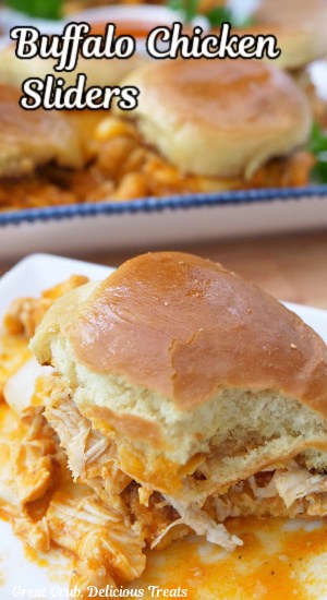 A white plate with a shredded buffalo chicken slider on it.