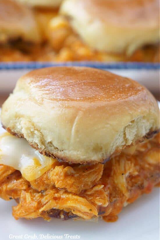 A small white plate with a single buffalo chicken slider on it.