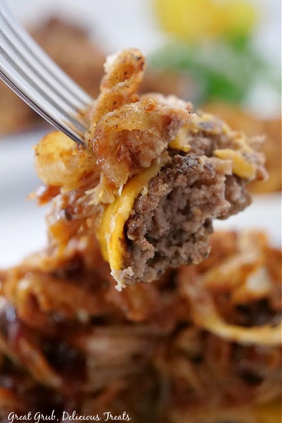 Bunless Burgers are the best way to use leftover pulled pork. A bite of hamburger patty on a fork with onion strings and pulled pork on top.