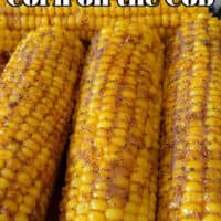 A close up photo of four ears of corn in a glass baking dish.