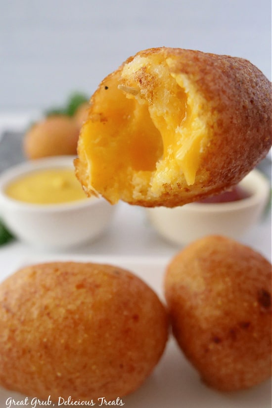 Cheese Bites are a quick, easy, and absolutely delicious snack. A bite taken out of a cheese bite showing melted cheese in the middle.