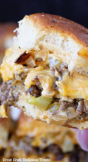 A close up photo of a cheeseburger slider with a bite taken out of it.