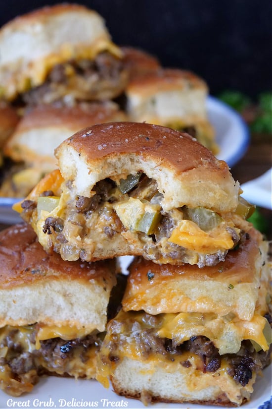 A small stack of sliders with a bite taken out of one of them.