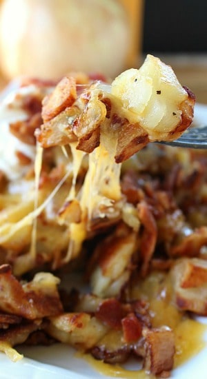 A fork with a bite of breakfast potatoes on it.